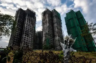 Flowers are seen in front of the Wang Fuk Court apartment blocks in the aftermath of the deadly November 26 fire in Hong Kong's Tai Po district on December 3, 2025.