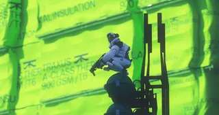 A thief stands watch over a green fluorescent background.